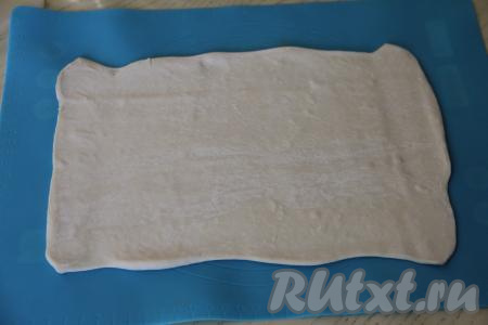 Пласт теста на присыпанной мукой поверхности раскатать в прямоугольник толщиной примерно 3 миллиметра.