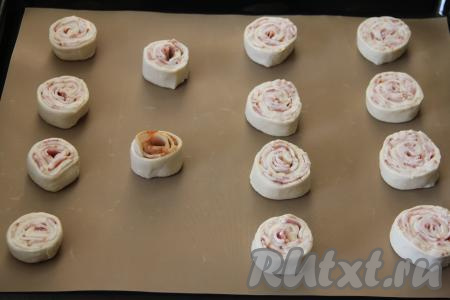 Выложить рулетики на небольшом расстоянии друг от друга на противень, застеленный тефлоновым ковриком или пергаментом. У меня получились 14 рулетиков.