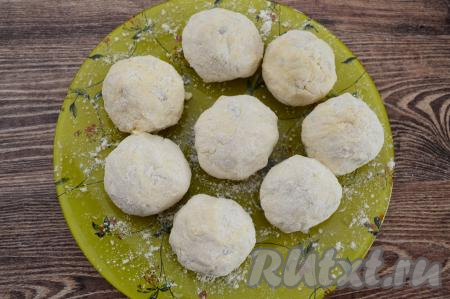 Постепенно руками, смоченными водой, сформировать и обвалять в муке все сырники. Сформированные сырники выкладывать на тарелку (или доску), присыпанную мукой. Я советую обязательно смачивать руки водой перед формовкой сырников, тогда липкое творожное тесто не сильно пристаёт к ладоням, а сами сырники хорошо обваливаются в муке.