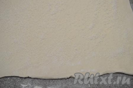 Присыпать поверхность раскатанного теста сахаром, отступив от краёв теста по 1 сантиметру.