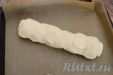 Аккуратно переложить рулет с бананом на противень, застеленный бумагой для выпечки.