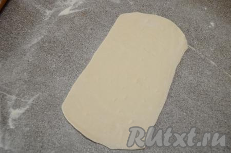 На припылённой мукой поверхности раскатать вначале одну часть теста в вытянутый прямоугольник толщиной около 2 миллиметров (ориентировочно размеры прямоугольника должны быть 24 сантиметра на 12 сантиметра).