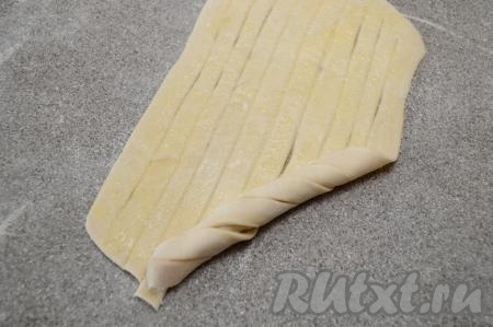 Начиная с одного из углов, как на фото, скрутить тесто наискосок в рулет.