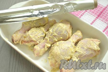  Дно формы для запекания смазываем растительным маслом, выкладываем куриные голени, покрытые майонезом с чесноком. Форму накрываем фольгой и отправляем в духовку, заранее разогретую до 190 градусов.