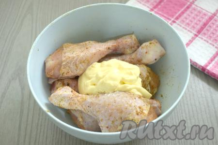 К замаринованным куриным голеням добавляем смесь майонеза и чеснока. Хорошо перемешиваем, покрывая ножки майонезом со всех сторон.