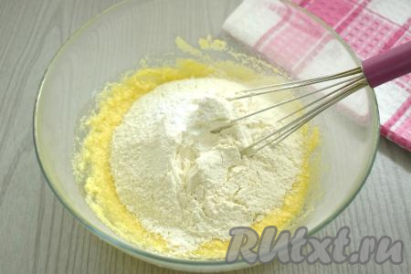 Всыпаем половину просеянной пшеничной муки вместе со всем разрыхлителем, перемешиваем тесто венчиком. Затем, подсыпая частями оставшуюся муку, замешиваем тесто для печенья. Как только перемешивать тесто венчиком станет сложно, продолжаем замешивать его руками.