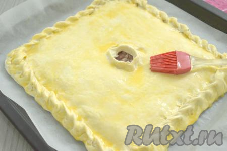 В небольшой ёмкости взбиваем яичный желток вилкой до однородности. С помощью силиконовой кисти смазываем поверхность пирога взбитым желтком.