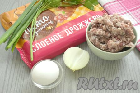 Подготовим продукты для приготовления пирога с фаршем из слоёного дрожжевого теста. Слоёное дрожжевое тесто заранее достаём из морозилки и оставляем оттаивать при комнатной температуре. Тесто должно стать мягким. Очищаем лук. Свежую зелень (у меня - петрушка и зелёный лук) моем, немного обсушиваем. Фарш можно взять любой (например, свиной, говяжий, куриный или из нескольких видов мяса). Я приготовила фарш в домашних условиях, пропустив кусочки свинины через мясорубку.