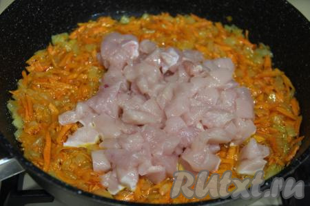 Обжарить овощи в течение 5-6 минут (до мягкости морковки), иногда перемешивая. Куриное филе нарезать на мелкие кубики, добавить в сковороду с обжаренными овощами, перемешать.