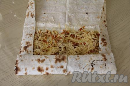 Если лаваш прямоугольной формы, тогда, начиная с более узкой стороны, свернуть лаваш с начинкой в рулет.