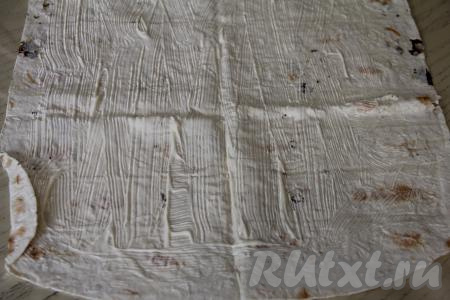 Расстелить на столе лист лаваша. Смазать лаваш майонезом, отступая от краёв лаваша по 1,5-2 сантиметра.