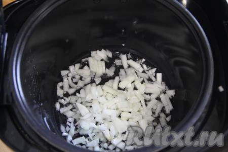 В чашу мультиварки влить растительное масло, выставить режим "Жарка" на 10 минут. Выложить мелко нарезанный лук.