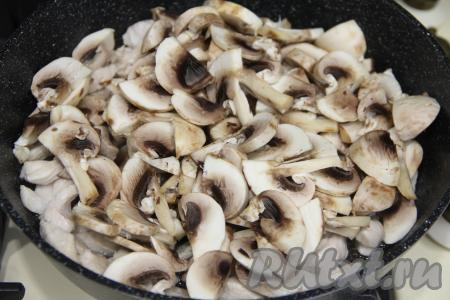 К обжаренному куриному филе добавить шампиньоны, нарезанные на пластины (или предварительно отваренные и нарезанные на части лесные грибы), перемешать.