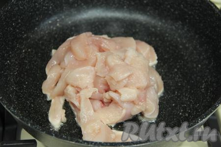 Куриное филе промыть водой, немного обсушить, нарезать на средние брусочки. В сковороду влить растительное масло, хорошо его разогреть, уменьшить до среднего огонь, выложить куриное мясо, нарезанное на брусочки.&nbsp;