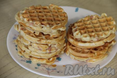 Готовую вафлю переложить на тарелку. Периодически перемешивая тесто, постепенно испечь все венские вафли с колбасой и сыром, складывая их стопочками на плоскую тарелку. У меня всего получились 14 вафель диаметром 10 сантиметров.