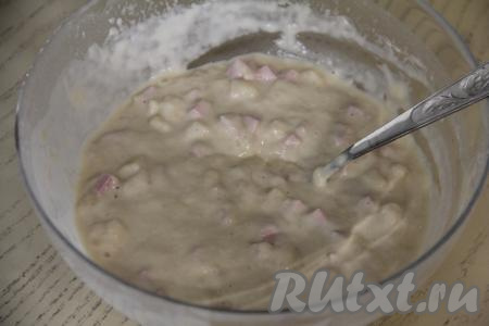 Вмешать колбасу и сыр в тесто столовой ложкой, равномерно распределяя по всему тесту.