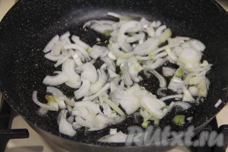 В сковороду влить растительное масло, разогреть, выложить лук, нарезанный на тонкие полукольца (или четверть кольца).