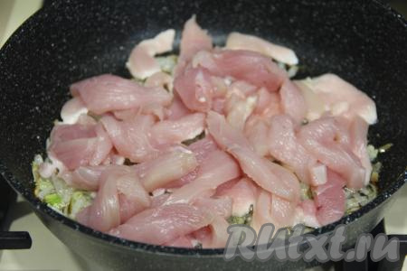 К обжаренному луку добавить куриное филе, нарезанное на брусочки, перемешать.