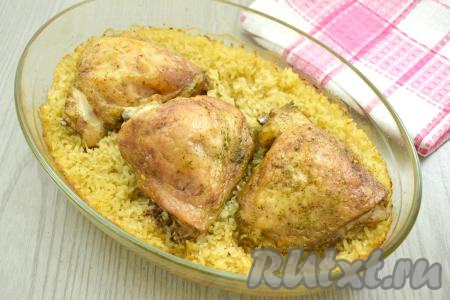 Отправляем форму в духовку, прогретую до 180 градусов. Запекаем рис с куриными бёдрами 40 минут. Затем фольгу убираем. Готовим в духовке при той же температуре ещё 20 минут. Бёдрышки за это время аппетитно подрумянятся. Рис должен стать мягким, хорошо пропаренным, вода испарится. Если рис остался твердоватым (многое зависит от сорта риса), тогда увеличьте время запекания на 5-10 минут.