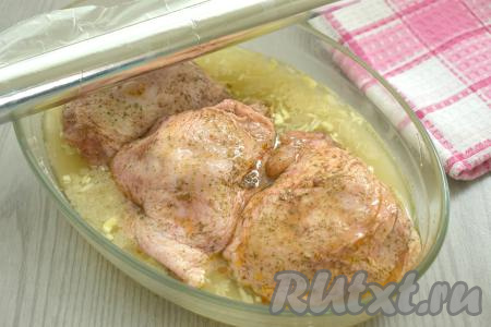 Сверху на рис выкладываем куриные бёдра, промариновавшиеся в специях. Форму накрываем фольгой.