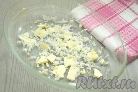 Форму для запекания смазываем частью сливочного масла. Оставшееся сливочное масло делим на части и распределяем по дну формы. Лук и чеснок очищаем, нарезаем мелко и выкладываем на дно формы.