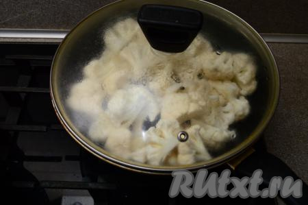 Когда вода закипит, накрыть сковороду крышкой, жарить капусту 3 минуты на огне ниже среднего, затем перемешать.