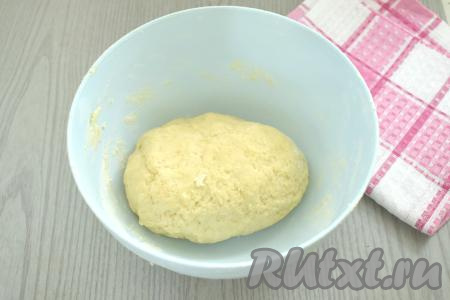 Вначале перемешиваем тесто столовой ложкой, а после того как оно начнёт собираться в ком, продолжаем замешивать его руками, всыпая понемногу оставшуюся муку и очень хорошо вмешивая её. Очень важно, добавляя понемногу муку, учитывать, что тесто в процессе замеса должно получиться в меру мягким, не липнущим к ладоням. Как только добились нужной консистенции теста, значит не нужно больше добавлять муку.