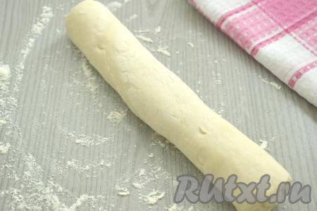 Размороженное тесто выкладываем на стол, посыпанный мукой. Сворачиваем плотно тесто в рулет.