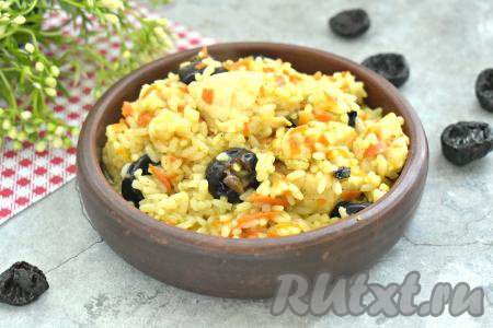 Аппетитный, вкусный, ароматный плов, приготовленный с курицей и черносливом, раскладываем по тарелкам и горячим подаём к столу.