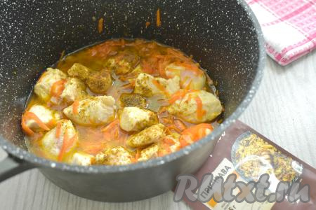 По прошествии 10 минут к обжаренному мясу курицы и овощам всыпаем приправу для плова (вы также можете использовать подходящие для плова специи - куркуму, кориандр, барбарис), перемешиваем. Вливаем 100 миллилитров воды, перемешиваем, даём воде закипеть. Уменьшаем огонь, тушим курицу с овощами 5 минут.