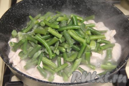 Затем добавить в сковороду замороженную (или предварительно отваренную) стручковую фасоль.&nbsp;