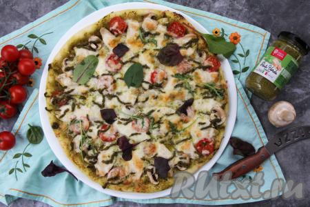 Готовую пиццу достать из духовки, переложить на тарелку. Можно поверх горячей пиццы выложить листья салата.&nbsp;