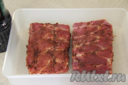 По желанию, чтобы придать остроту рёбрышкам, добавить аджику, равномерно распределяя её по мясу. Переложить рёбра в удобную плоскую ёмкость (у меня - пластиковый лоток).