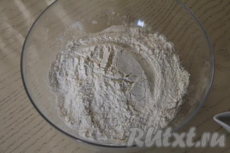 В миску с запенившейся дрожжевой смесью влить растительное масло, всыпать 100 грамм муки, соль и сахар, перемешать столовой ложкой. Постепенно начать всыпать оставшуюся муку, каждый раз хорошо вмешивая её. После того как в процессе добавления муки перемешивать тесто ложкой станет сложно, продолжать замешивать его руками.