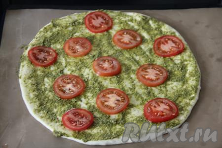 Помидоры вымыть, нарезать на тонкие кружочки, выложить поверх теста, смазанного соусом песто.