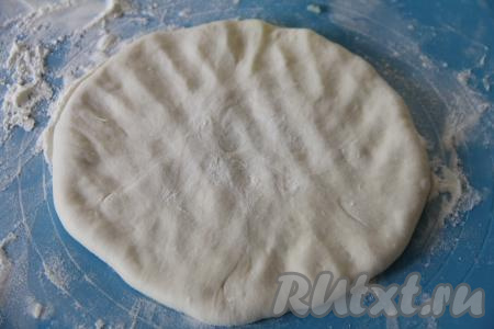 Перевернуть мешочек швом вниз и аккуратно руками растянуть тесто с начинкой в плоскую лепёшку.