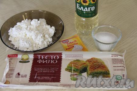 Подготовить продукты для приготовления ватрушек с творогом из теста фило. Для получения начинки для ватрушек нужно соединить в миске творог любой жирности, сахар и ванильный сахар, перемешать до однородности и творожная начинка для ватрушек готова. У меня тесто фило было в вакуумной упаковке, оно продаётся в незамороженном виде. Если у вас тесто фило заморожено, тогда, не нарушая целостность упаковки, его нужно полностью разморозить.