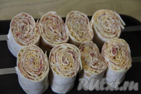 Нанизать рулетики на шампуры, как на фото, и плотно придвинуть друг к другу.