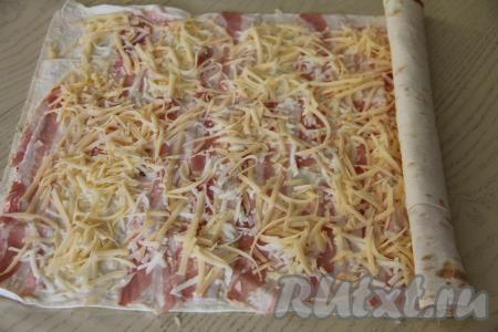 Свернуть лаваш с начинкой в плотный рулет, начиная с узкого края.