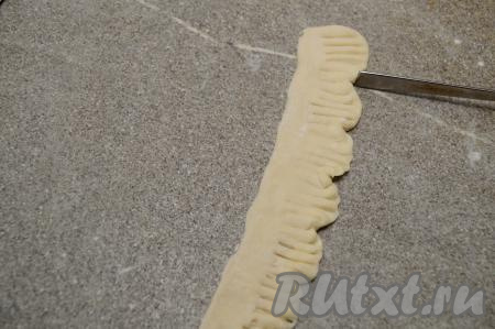 Тупым концом обратной стороны ложки на стороне теста с зазубренками сделать небольшие углубления, формируя как бы небольшие лепестки.&nbsp;Аналогично сформировать все 8 таких полосок из теста с лепестками.