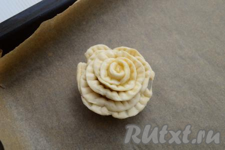 Противень застелить пергаментом, выложить на противень заготовку слойки и расправить полоски наружу, как бы формируя лепестки цветка.