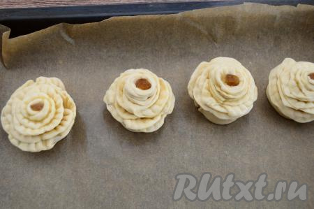 Аналогично сформировать все 4 цветка, поставить их на противень. В середину каждого цветочка можно поместить по одной изюминке для украшения. Изюм я предварительно промыла водой и обсушила, выложив на бумажную салфетку.