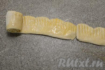 Выложить две полоски теста одна за другой, как на фото. И, начиная сворачивать с узкой стороны первой полоски, сформировать из двух полосок один рулет.
