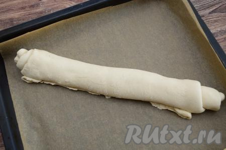 Хорошо прижать край теста к рулету. На противень, застеленный пергаментом, выложить сформированный рулет швом вниз.