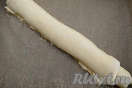 Отложенный ранее желток взболтать вилкой до однородности, смазать им поверхность рулета.