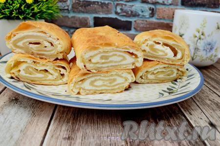 Достать готовую выпечку из духовки, дать немного остыть, а затем можно нарезать на кусочки и подавать к столу.&nbsp;Рулет из слоёного теста&nbsp;с творогом получается очень нежным, в меру сладким. Отличная выпечка для домашнего чаепития!