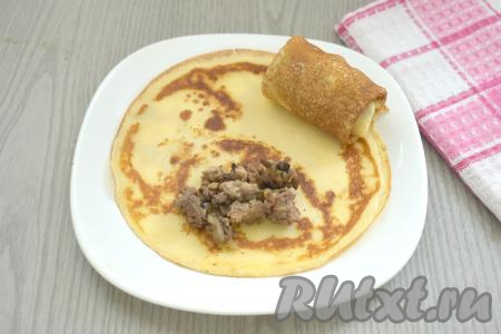 Приступаем к фаршировке блинов. На блинчик ближе к одному из краёв выкладываем 1 полную столовую ложку начинки из фарша и грибов. Подворачиваем вначале боковые края блина на начинку, а затем, начиная со стороны с начинкой, сворачиваем блинчик в рулетик. Так фаршируем все блины. Всего у меня получились 16 блинов с фаршем и грибами.