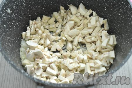 К обжаренному луку добавляем шампиньоны, нарезанные на небольшие кубики, обжариваем 5 минут, иногда помешивая.