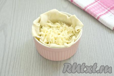 ​​​​​​​​​​Натираем сыр на крупной тёрке. Равномерно распределяем натёртый сыр по&nbsp; формочкам.