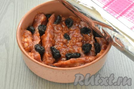 Свиные рёбра, покрытые томатным соусом, выкладываем в форму для запекания. Поверх рёбер раскладываем подготовленный чернослив. Форму накрываем фольгой, сложенной в два слоя, и отправляем в духовку, разогретую до 180 градусов.